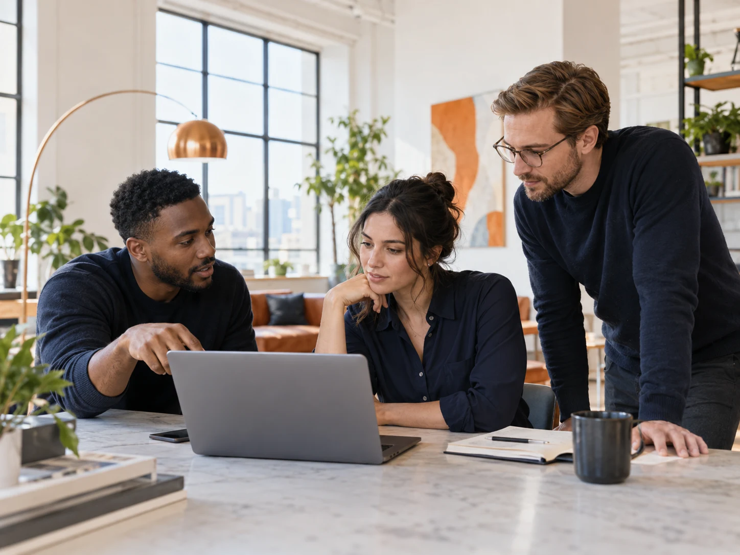Engineers working together around a laptop in a bright studio